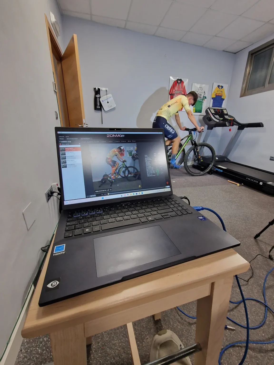 Estudio biomecánico: ciclista sobre el rodillo y el portátil con el análisis de la postura